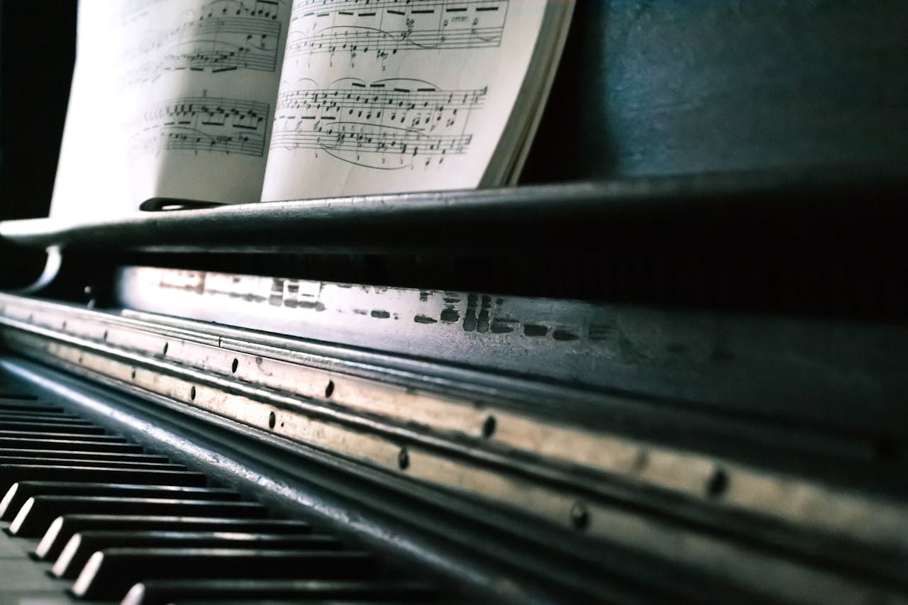 about-02 Close-up of piano keys with an open sheet music, creating a classic musical ambiance.